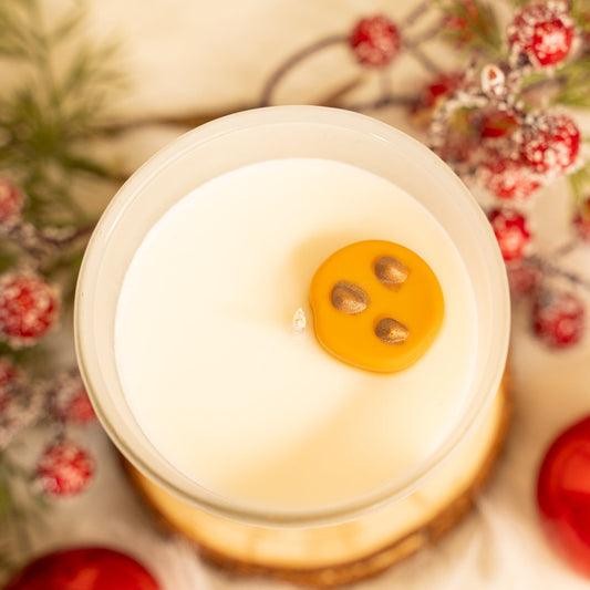 Close-up of a round white object with three holes on a decorative background with berries and pine cones.