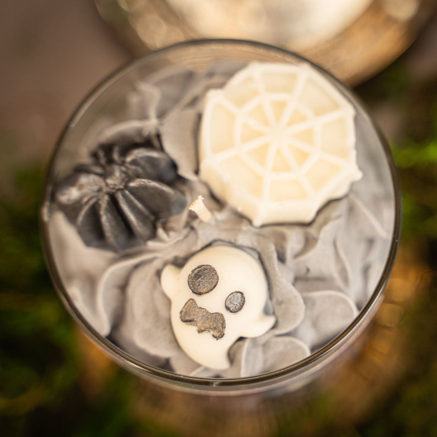 Decorative stones with skull and flower designs in a glass container.