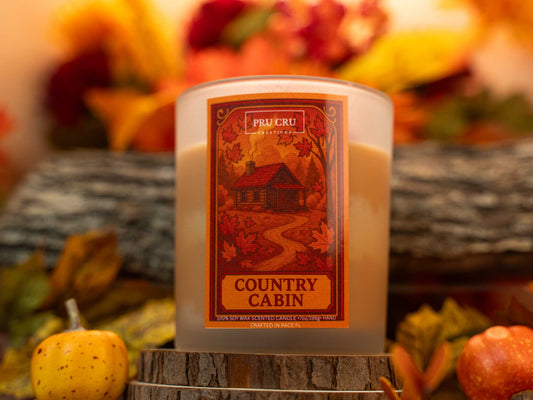 Candle with 'Country Cabin' label in front of autumn-themed background