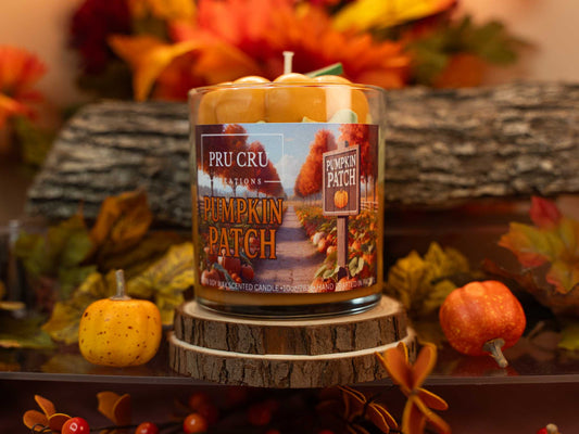 Pru Cru Pumpkin Patch candle on a wooden stand with fall-themed decorations.