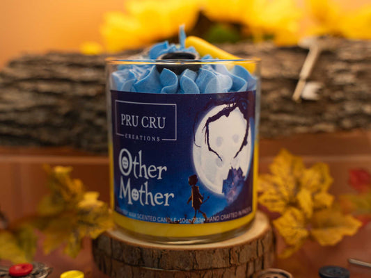 Candle with blue wicks and a label on a wooden block, surrounded by autumn leaves.