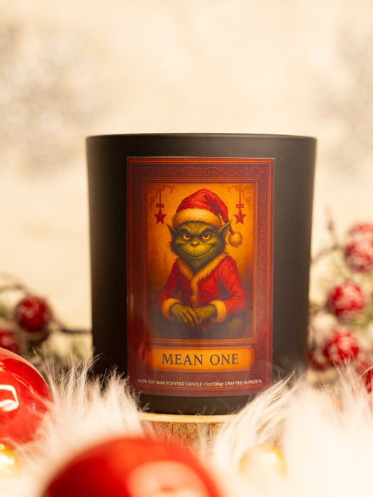 Candle with a festive label featuring a character in a Santa hat on a blurred background.