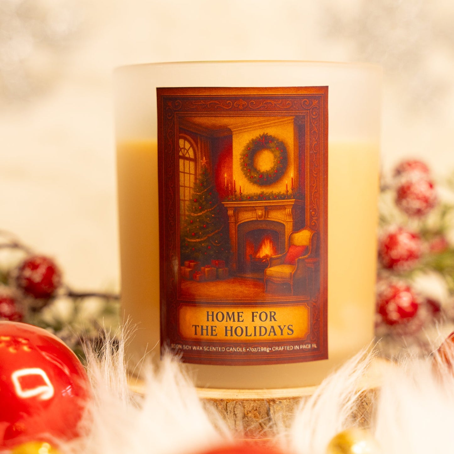 Candle with a decorative label featuring a Christmas scene, surrounded by festive decorations.