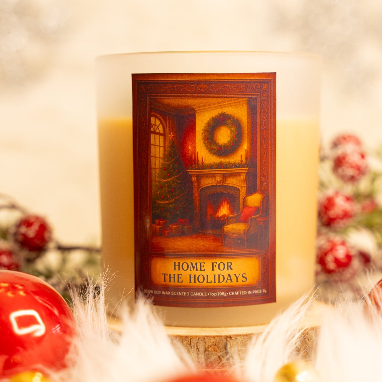 Candle with a decorative label featuring a Christmas scene, surrounded by festive decorations.