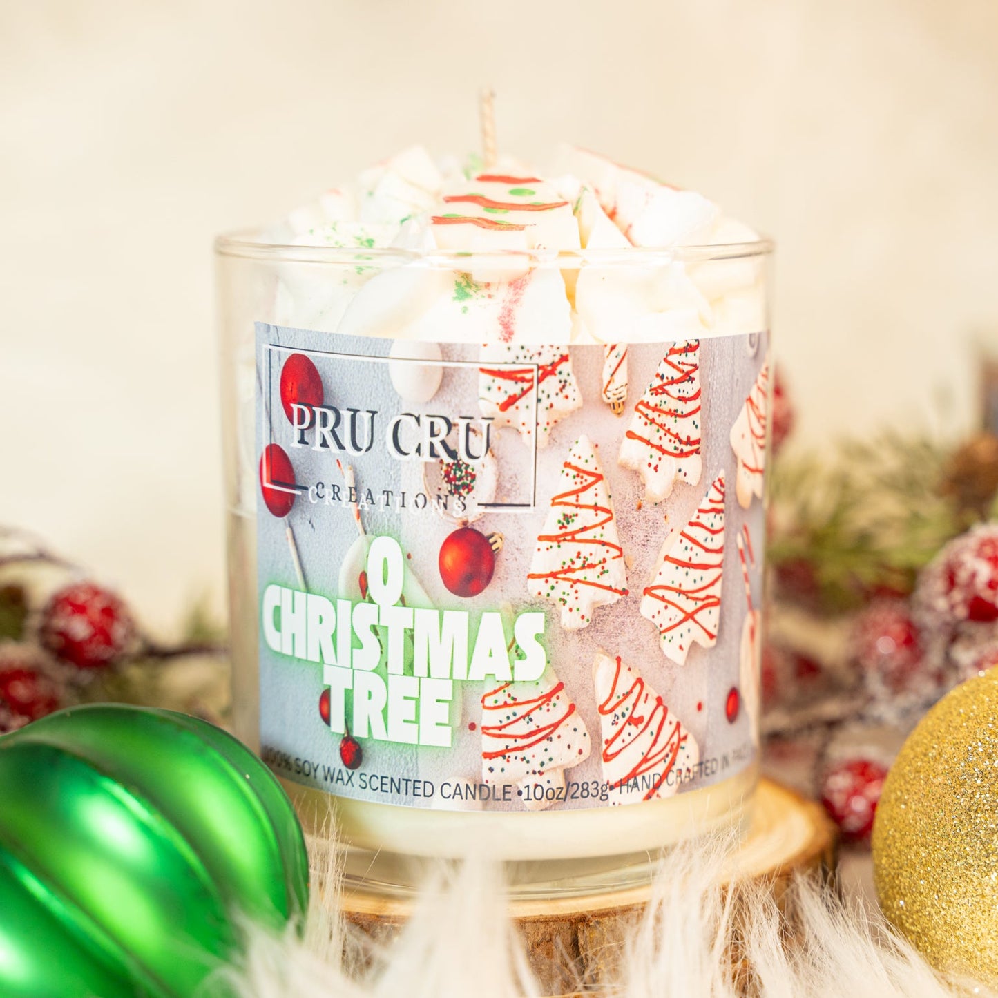 Candle with a Christmas tree label surrounded by festive decorations