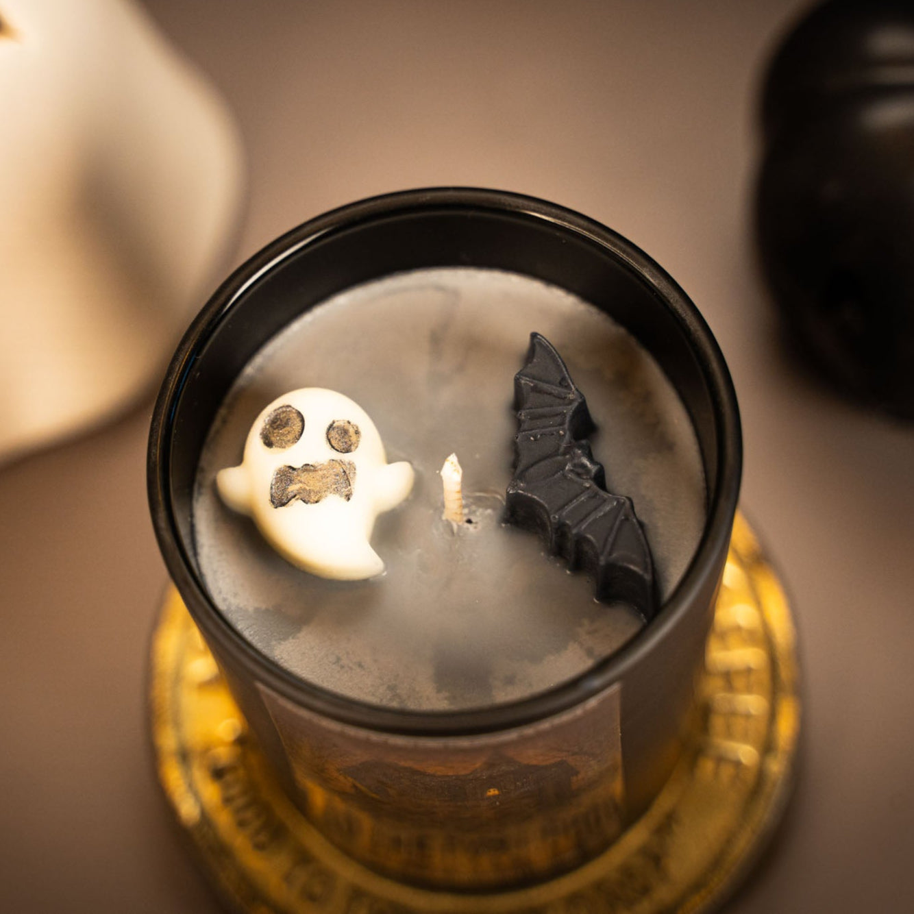 Halloween-themed candle with decorative elements on a blurred background