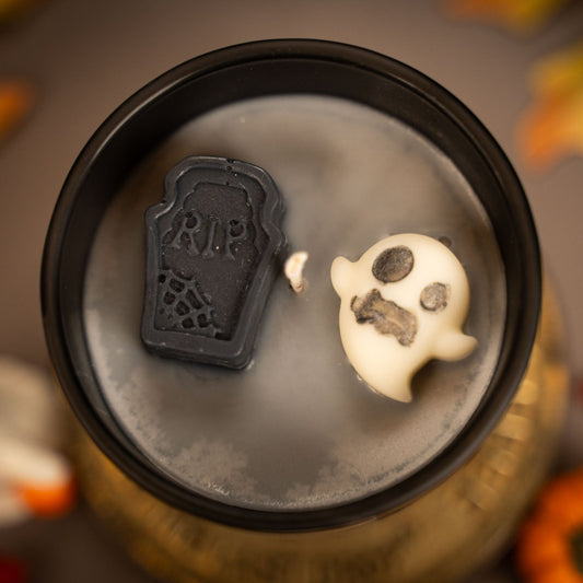 Halloween-themed lid with skull and tombstone design on a blurred background