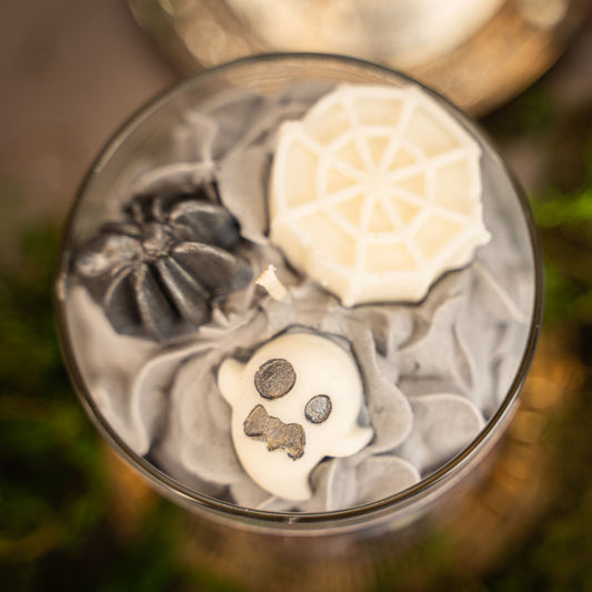 Decorative stones with skull and flower designs in a glass container.